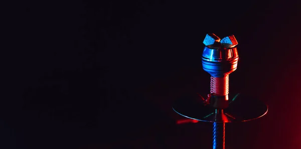 Горячие красные угли для кальяна шиша в керамической металлической миске с красно-синим неоновым освещением на черном фоне — стоковое фото
