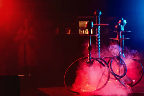 Hookahs στο τραπέζι με καπνό και κόκκινο και μπλε φως στο lounge cafe — Φωτογραφία Αρχείου