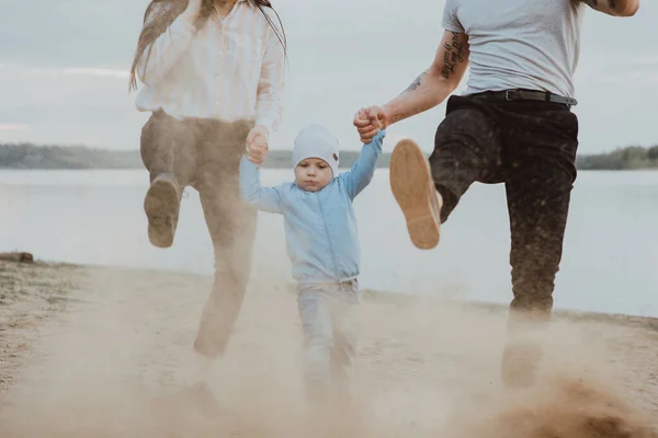 Glückliche junge Familie mit kleinem Sohn beim Spielen im Sand — Stockfoto