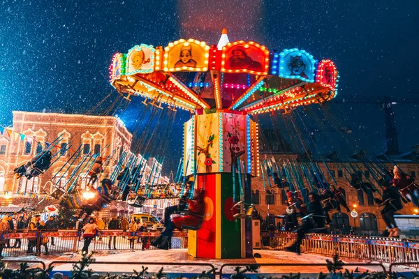 MOSCOW, Oroszország - JANUÁR 31, 2020: Körhinta piros téren díszített karácsonyi díszek Moszkvában az emberek éjjel télen — Stock Fotó