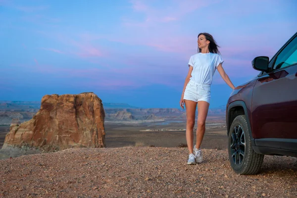 Beyaz yaz kıyafetli genç esmer kadın Off-Road Aracında poz veriyor Stud Horse Point, Page, Arizona