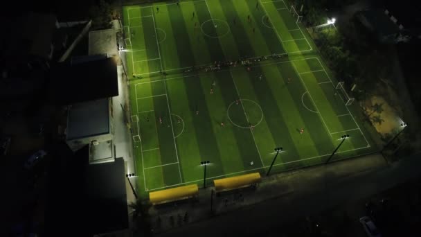 Luchtfoto. Bovenaanzicht van twee voetbalvelden op moment van de nacht. Teams spelen op voetbal. — Stockvideo