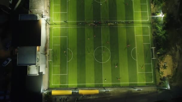 AERIAL. Vista superior de dois campos de futebol à noite. Equipas que jogam futebol . — Vídeo de Stock