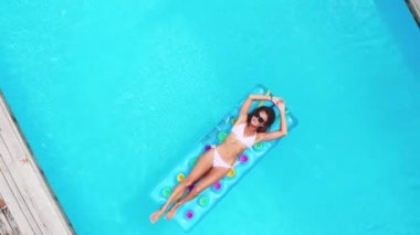 Hava. Üstten görünüm. Kamera yakınlaştırma. Bikini giyen neon parlak yüzme yatak Lüks villada orman, havuzda ile poz genç seksi kız portresi açık hava yaşam tarzı ve
