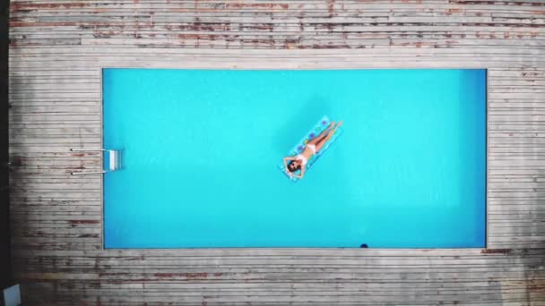 顶部视图 摄像机向上移动 户外生活的肖像年轻漂亮性感的女孩摆在游泳池的霓虹灯明亮的游泳床垫 穿着比基尼和太阳镜 放松和乐趣 — 图库视频影像