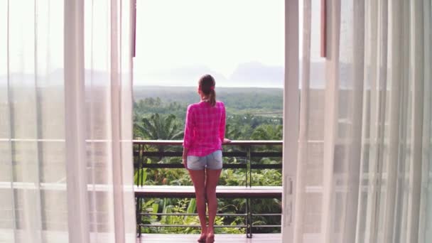 Hermosa mujer disfrutando de la vista desde el balcón en la selva en Bali — Vídeos de Stock