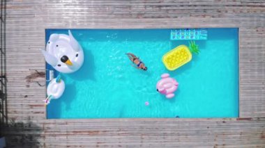 Dinlenmek için zaman. Çekici genç kadın lüks jungle view Villa havuzunda rahatlatıcı bikini üstten görünüm.