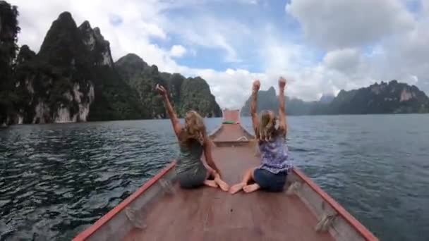 Dua wanita bahagia bepergian dengan perahu dan menikmati matahari. Dua gadis mengangkat tangannya . — Stok Video