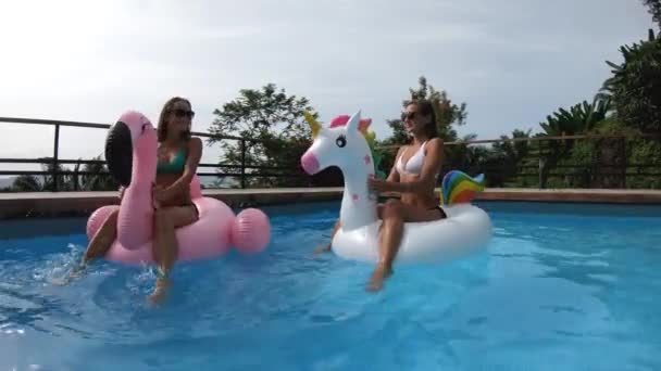 两个朋友在一个有游泳池的私人别墅里举行聚会-快乐的年轻人带着形状好的空气床垫 — 图库视频影像