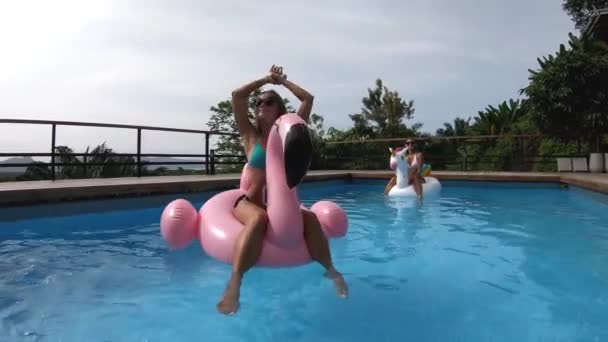 Två vänner som har fest i en privat villa med pool - Glada ungdomar som chillar med formade luftmadrasser — Stockvideo