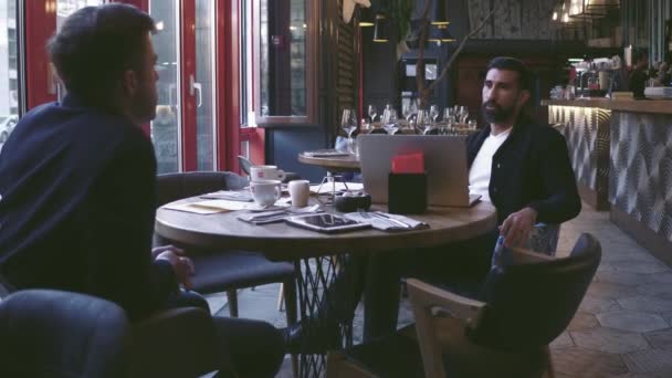 Business partners meeting. Two successful businessman stitting in a restaurant and talk to each other. — Stock Video