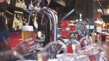 Taze Bira döküyor. Yakın çekim Genç barmen barda bira dururken dökme, sayaç