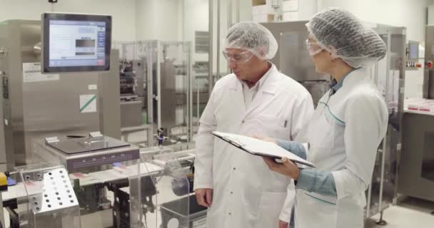 Dois engenheiros de fábrica de medecina discutindo o processo de trabalho , — Vídeo de Stock