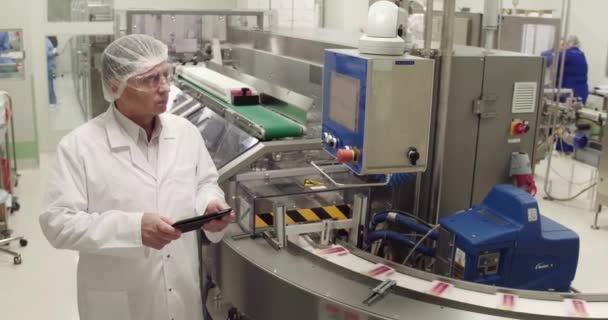 Medecine specialist using digital tablet while taking inventory in pharmaceutical factory. — Stock Video