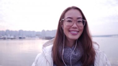 Kentsel arka planda gülümseyen göz gözlük ile güzel bir Asyalı kadın portresi dolgu.