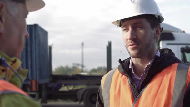 Portrait de jeune spécialiste en chapeau blanc explorant le travail pour l'employeur adulte au quai . — Video