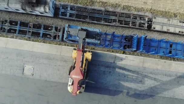 Containers zijn aan een blok-trein wordt opgeheven door middel van een transtainer. Luchtfoto, top uitzicht. — Stockvideo