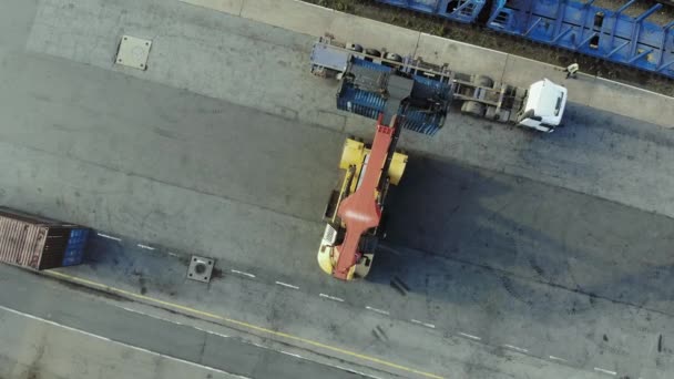 Los contenedores están siendo levantados en un tren de bloques por medio de un transtainer. Aérea, vista superior . — Vídeo de stock