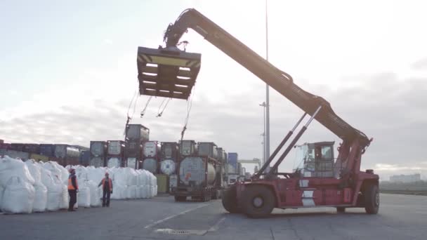 Kranförare och mobilkran maskin stå genom att vänta på att lyfta vita påsar i dockan. — Stockvideo