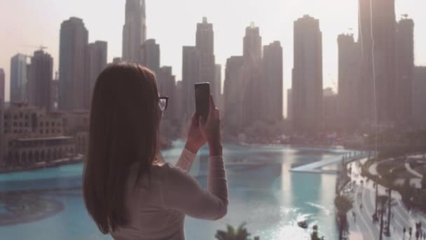 Молодая Женщина Печатает Телефону Большого Окна Смотрит Здания Дубая Закат — стоковое видео