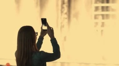 Kadının çeşmeler gösteri dans fotoğraf çekimi smartphone ile Arkadan Görünüm