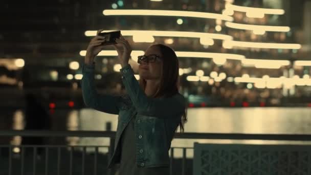 Heureuse femme blonde - touriste tourné sur son smartphone caméra belle vue sur la ville avec bokeh, sur la rivière dans la journée ensoleillée . — Video