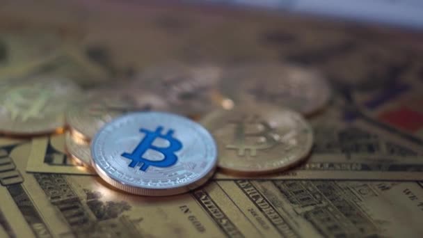 Kamera bergerak di sekitar koin bitcoin dan uang emas dolar dan euro di latar belakang. — Stok Video