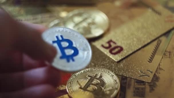 Man menempatkan bitcoin di atas meja. Bitcoin emas pada dolar AS di tangan seorang pria. Simbol digital dari arus maya baru. Konsep pertukaran uang elektronik . — Stok Video