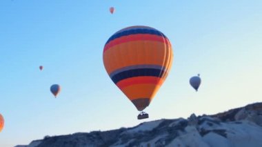 Türkiye 'nin Kapadokya kentindeki dağlık arazi üzerinde uçan sıcak hava balonları.
