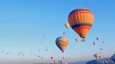 Türkiye 'nin Kapadokya kentindeki dağlık arazi üzerinde uçan sıcak hava balonları.