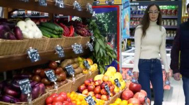 Babası süpermarkette meyve seçen Asyalı genç bir kadın.,