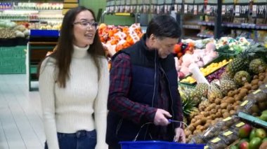 Babası süpermarkette avokado seçen Asyalı genç bir kadın.,