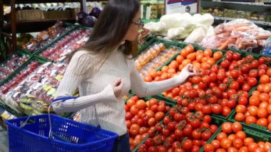 Domates seçimi sebze pazarında gülümseyen güzel bir genç Asyalı kadın Portresi.