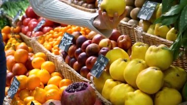 Meyve pazarında elinde elmayla bir kadın. Meyve ve sebze. Bir sürü meyve. Piyasa. Mağaza. Geçmişi. Citruslar. Sağlıklı yemek. Doğal yemek. Sağlıklı. Vejetaryen. diyet