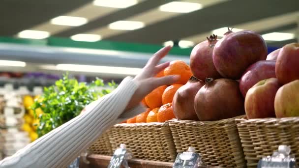 Asian woman in the fruit market with pomegrant in hand. fruits and vegetables. a lot of fruits. market. store. background. citruses. healthy food. natural.. food. health.VEGETARIAN. diet — Stock Video