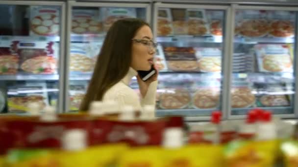 De Aziatische vrouw praten telefonisch in de supermarkt. — Stockvideo