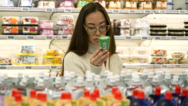 Азіатська жінка вибирає айсберг в супермаркеті . — стокове відео