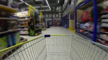 Panorama. Raflar aracılığıyla boş alışveriş sepeti ile Süpermarket koridor. Hızlı hız. Hızlı yakalama.