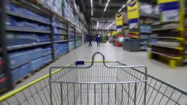 Panorama. corredor do supermercado com carrinho de compras vazio através de prateleiras. Rápido. Captura rápida . — Vídeo de Stock