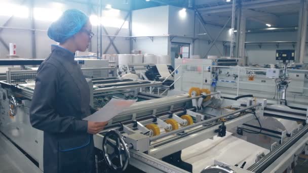 Asian woman worker checking how flexographic machine for multicolor printing on paper. — Stock Video