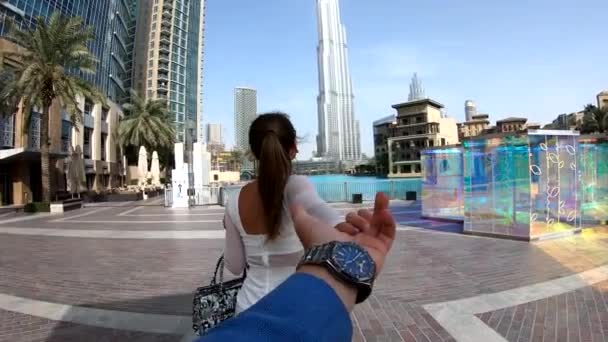 Πολυτελής ταξιδιωτική γυναίκα που κρατά το χέρι του συζύγου και την ακολουθεί, θέα από πίσω. Γυναίκα που κοιτάζει τη θέα στο Ντουμπάι διάσημο ταξιδιωτικό προορισμό. — Αρχείο Βίντεο