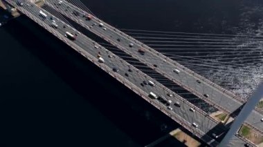 Drone ile asfalt yolda veya otobanda şehir araba trafik, kentsel ulaşım, büyük nehir üzerinde beton köprü hava veya üst görünümden tonda
