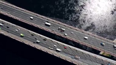 Drone ile asfalt yolda veya otobanda şehir araba trafik, kentsel ulaşım, büyük nehir üzerinde beton köprü hava veya üst görünümden tonda