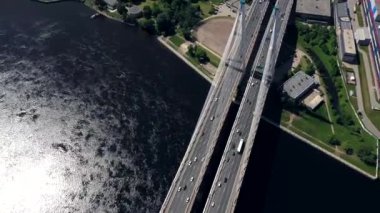 Drone ile asfalt yolda veya otobanda şehir araba trafik, kentsel ulaşım, büyük nehir üzerinde beton köprü hava veya üst görünümden tonda
