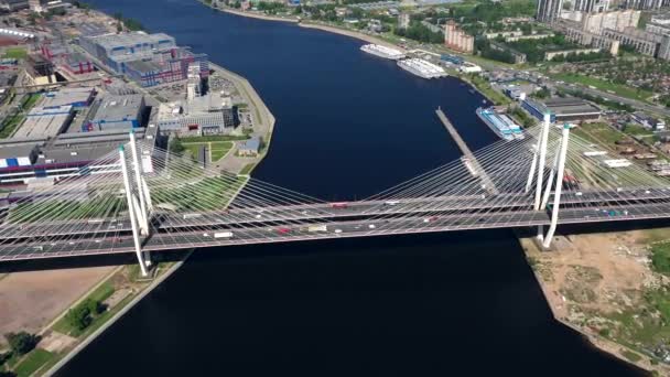 Luft- oder Drone von Betonbrücke mit Asphaltstraße oder Autobahn über großen Fluss mit Stadtautoverkehr, Stadtverkehr, getönte — Stockvideo