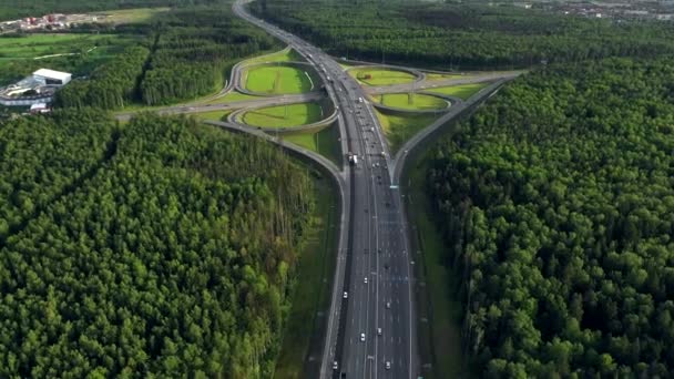 AERIAL. Dopravní výměna. Horní pohled na silnici, město a les. Letní video z dronu. — Stock video