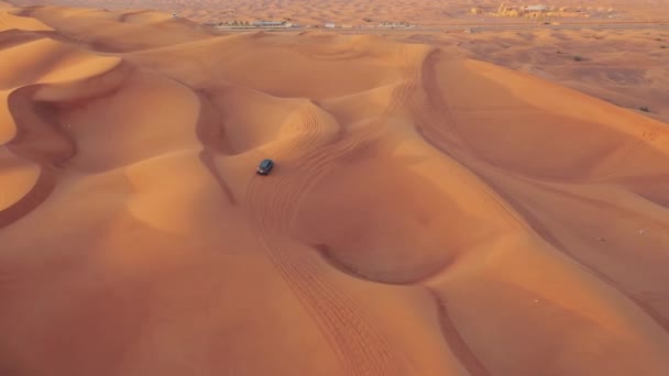 AERIAL. Vuelo de altura por encima del coche. Desierto safari coche arena corriendo en el desierto de Dubai durante la puesta del sol — Vídeos de Stock