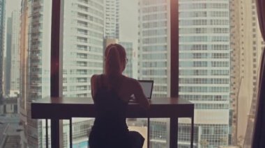 Güzel Başarılı İş Kadını Ofisinde Dizüstü bilgisayarında Şehir Manzarası Penceresi ile çalışıyor. Güçlü Independend Kadın CEO 'su İş Şirketi' ni yönetiyor. Arkasında Güneş parıldıyor.