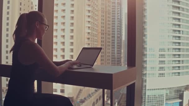 Mooie Succesvolle Zakenvrouw Werken op een laptop in haar kantoor met Cityscape View Window. Sterke onafhankelijke vrouwelijke CEO runt Business Company. Zon vlamt achter haar. — Stockvideo