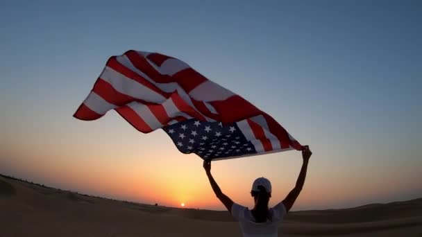 Ένας αθλητής με σημαία, που δείχνει αμερικάνικη σημαία. Όμορφη επευφημίες ευτυχισμένο νεαρό πολυπολιτισμικό κορίτσι χαρούμενος ενθουσιασμένος. — Αρχείο Βίντεο